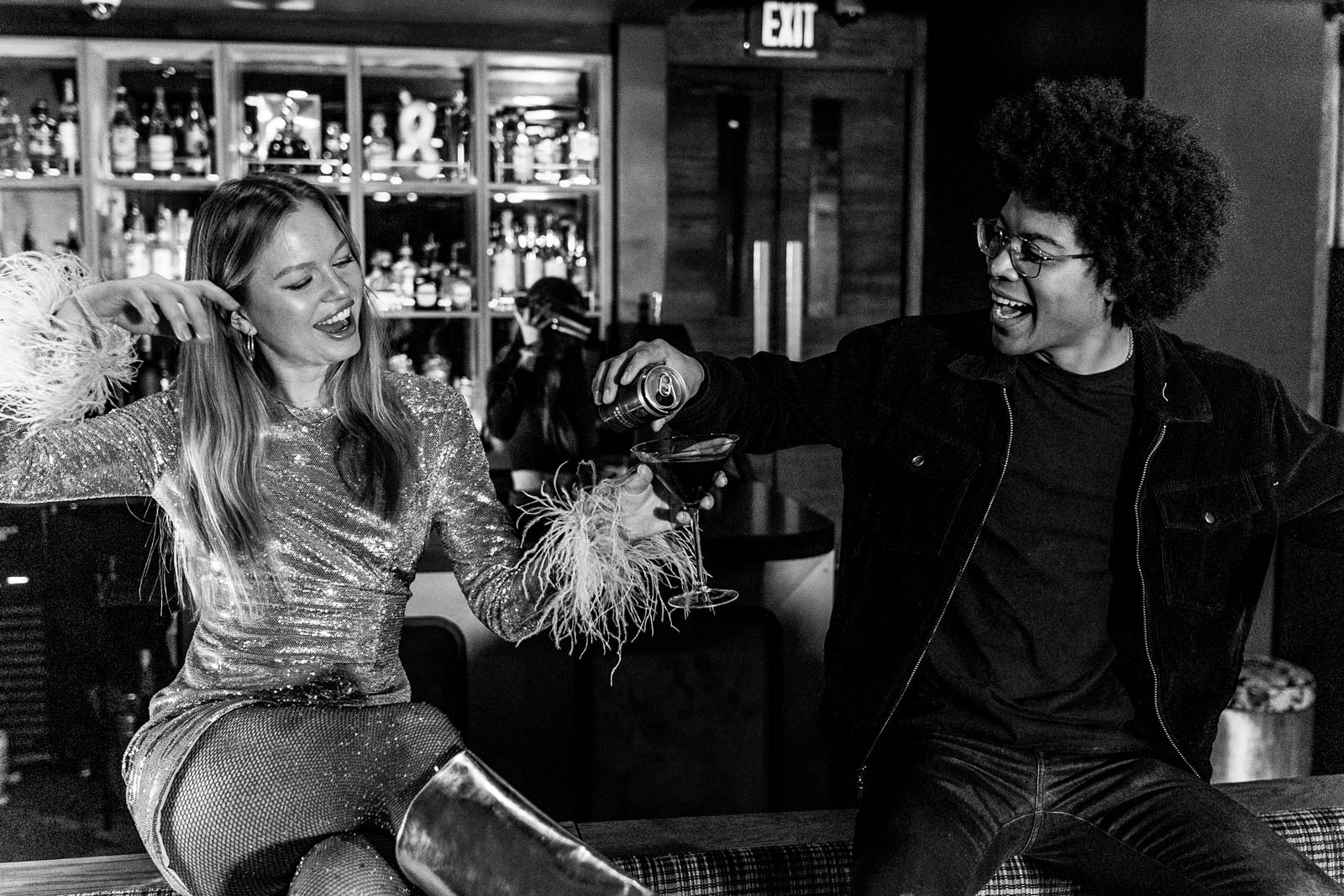 Two people in a night club enjoying NightOwl canned espresso vodka and tequila martinis