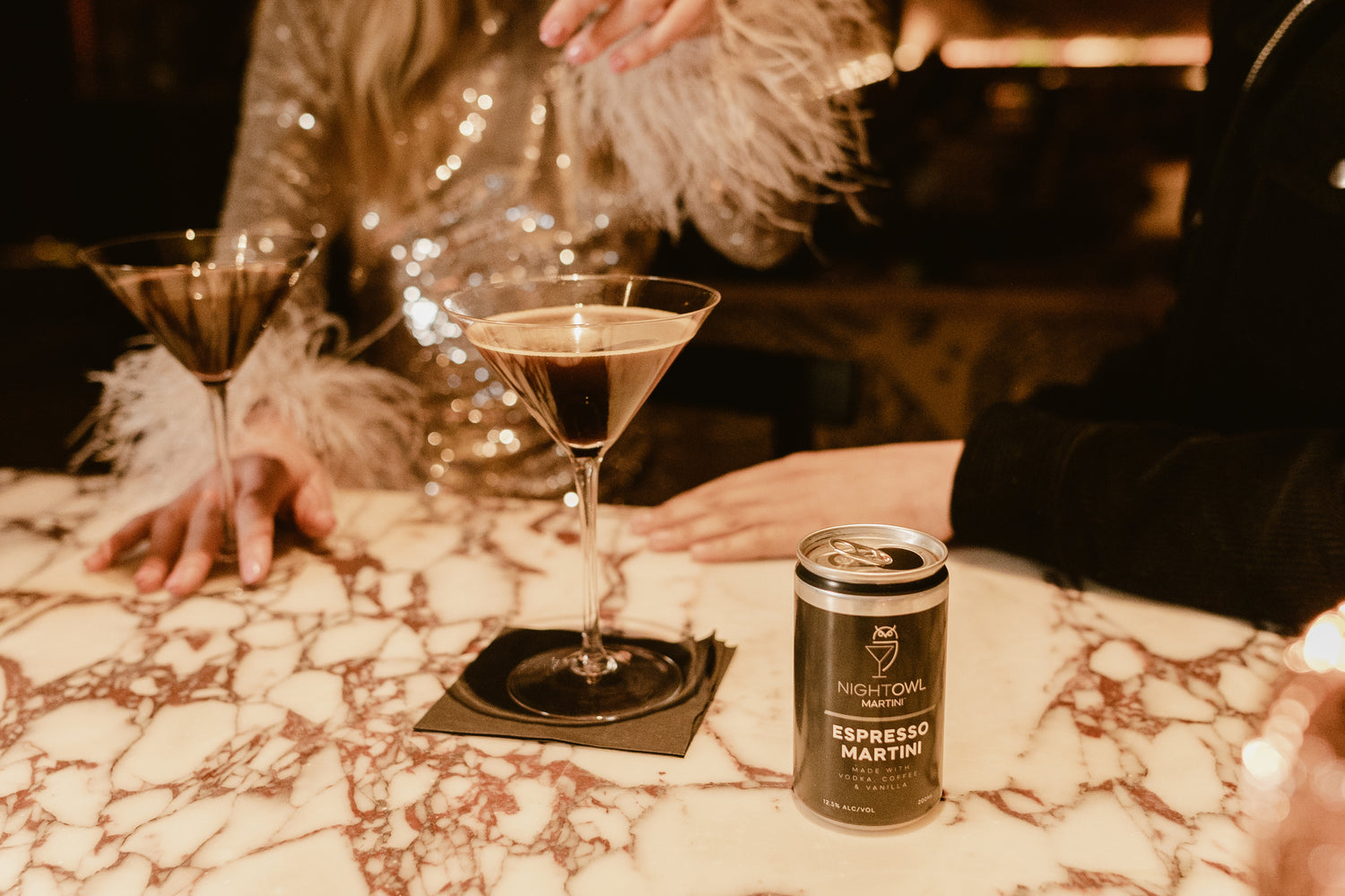 Fancy woman drinking a NightOwl espresso martini from a martini glass